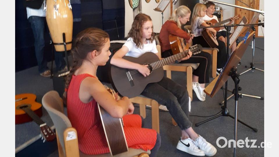 Musiklehrer Christian Nesner stellt seine Gitarrenklasse vor. Alle erhalten viel Beifall für ihre musikalische Reise. Bild: gi
