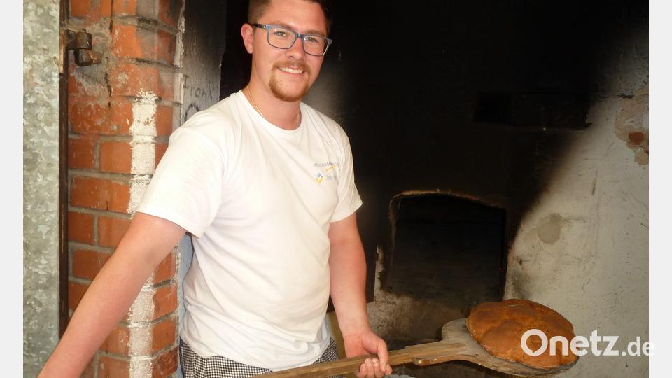 In diesem Jahr zum ersten Mal dabei der junge Bäcker Julian Brucker, der die beiden einheimischen Bäckermeister Seer tatkräftig unterstützte und hier das ofenfrische Bauernbrot mit dem Schieber aus dem Holzbackofen holt. Bild: bir