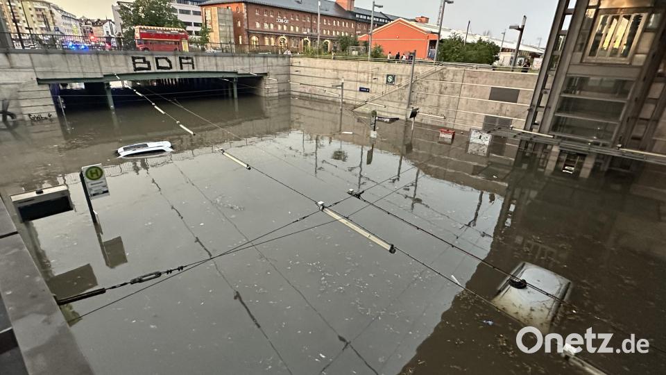 Autos, von denen man nur das Dach erkennen kann, stehen in einer überschwemmten Straße an einer Unterführung nach einem Unwetter. Bild: NEWS5/dpa