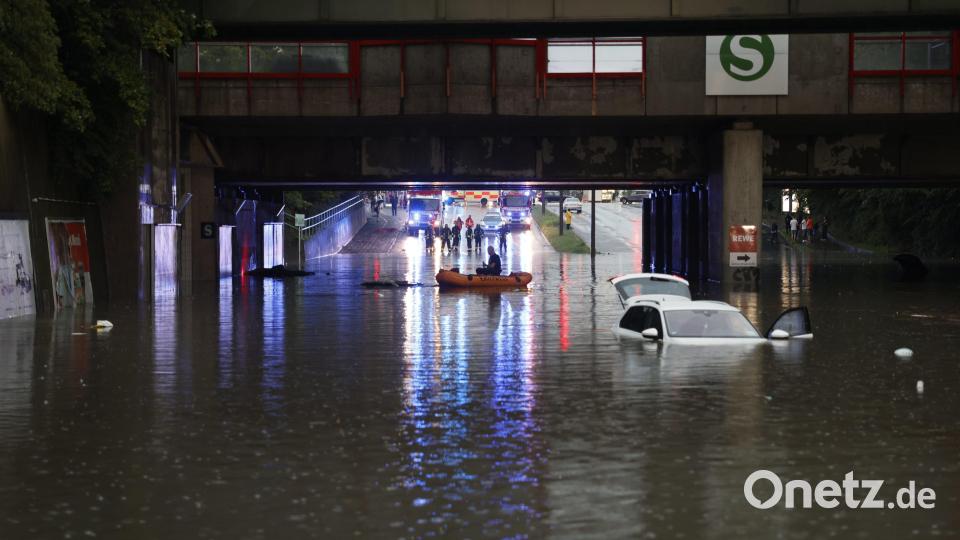 Einsatzkräfte der Feuerwehr können nur noch mit einem Schlauchboot zu den Autos in einer überschwemmten Unterführung gelangen. Bild: Oßwald/News5 /dpa