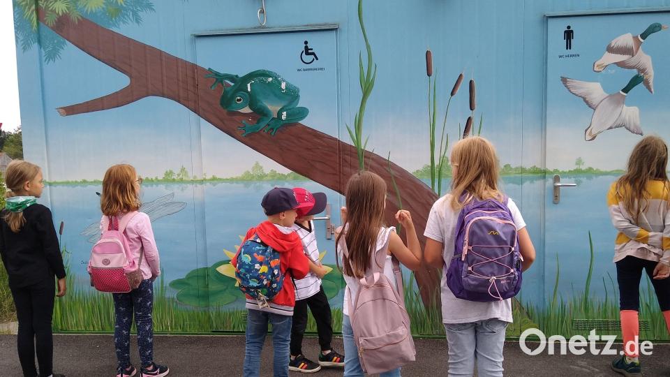 Bei den Vilsauen entdecken die Kinder Tiere, die an eine Wand gemalt sind. Bild: Adolfine Nitschke/exb