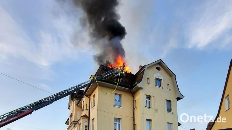 Dunkle Rauschwaden und Flammen steigen aus dem Dach des Mehrfamilienhauses. Bild: Stefan Klaubert/exb
