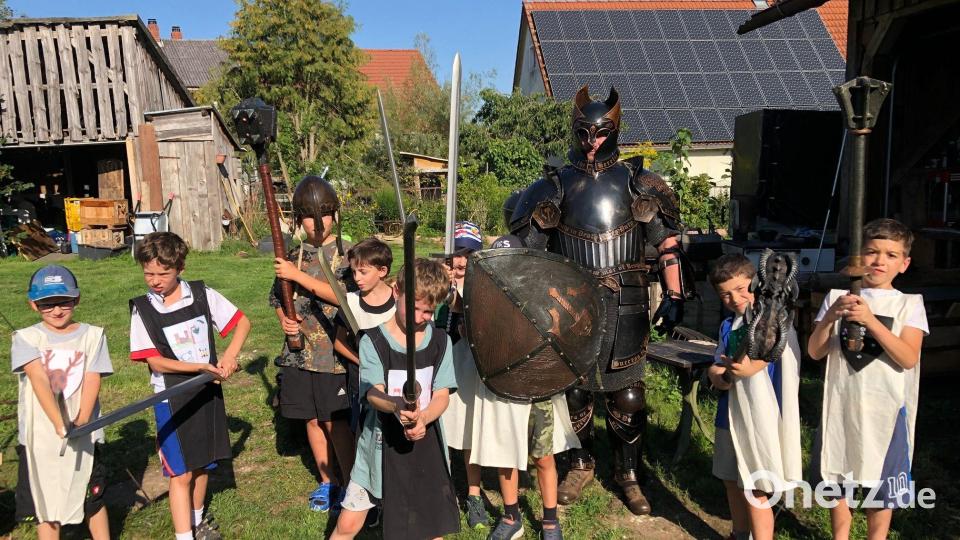 Die Kinder spielen mit mittelalterlichen Waffen einen historischen Kampf nach. Bild: Nina Plank/exb