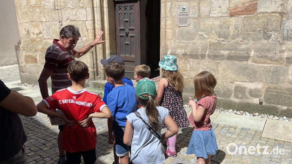 Gespannt schauen die Kinder auf die Tür, durch die sie der Weg hinauf auf den Turm der Pfarrkirche St. Johannes der Täufer führen wird. Bild: Klaus Riede/exb
