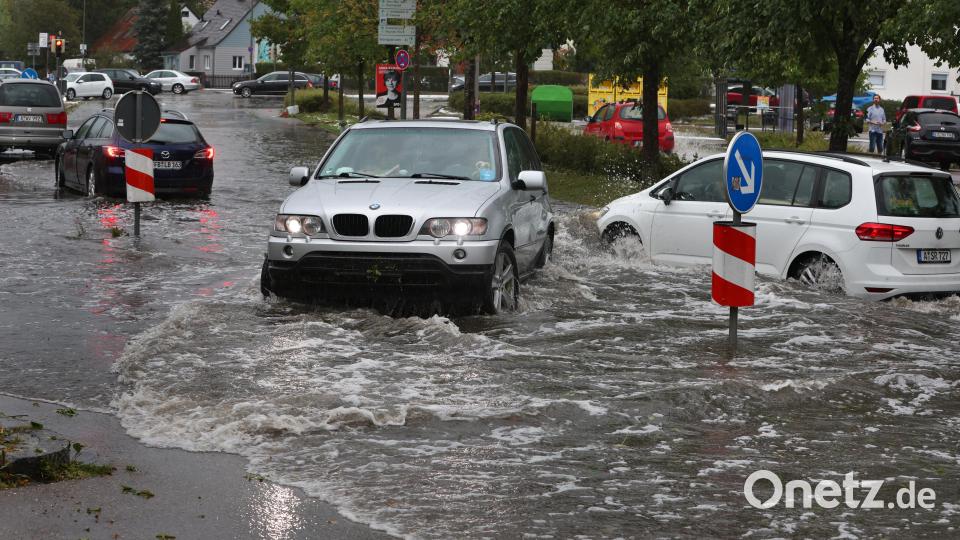 Autos fahren auf einer überfluteten Straße. Gewitter mit starkem Wind und Hagel haben am Samstagnachmittag für zahlreiche Einsätze in Schwaben gesorgt. Bild: Karl-Josef Hildenbrand/dpa