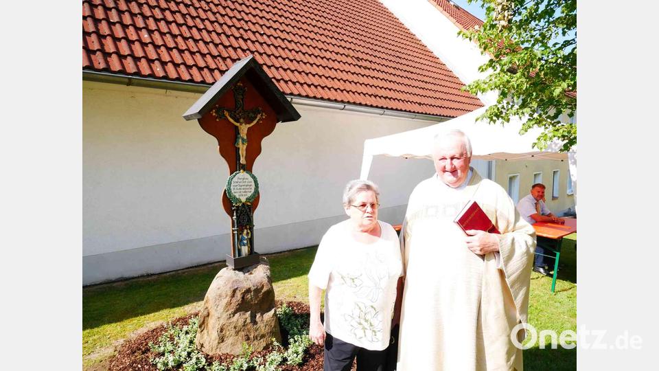 Pfarrer Erwin Bauer dankt Vorbesitzerin Monika Schneider für die Kreuzspende. Bild: gz