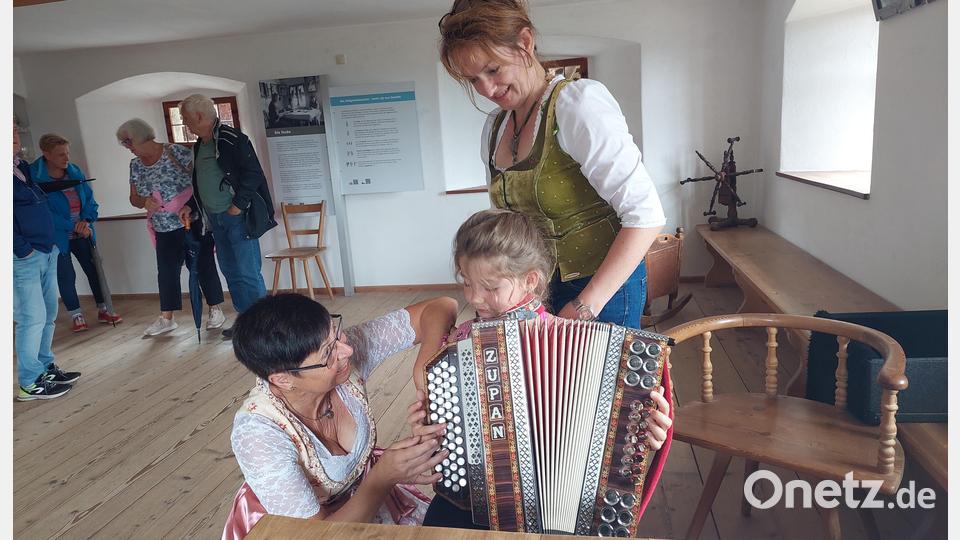 Der kleinen Valentina werden erste Griffe an der Harmonika gezeigt. Bild: jua
