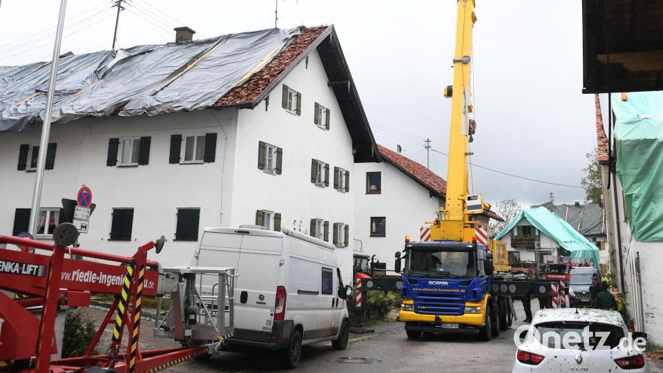 Nach dem Unwetter im Landkreis Garmisch-Partenkirchen sind die Dächer mehrerer Wohnhäuser mit Planen provisorisch abgedeckt. Aufgrund schwerer Unwetterschäden rief das Landratsamt Garmisch-Partenkirchen für den Ort mit rund 1300 Einwohnern am Sonntag den Katastrophenfall aus. 80 Prozent der Gebäude in dem Ort sollen schwer beschädigt sein. Bild: Felix Hörhager/dpa
