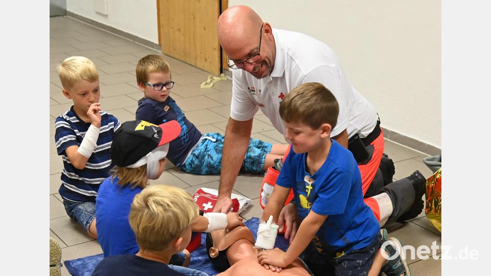 30 Mal kräftig auf das Brustbein drücken, dann Atem spenden und das gleiche Prozedere, bis der Patient aufwacht oder der Rettungsdient die Betreuung übernimmt. Die kleinen Ersthelfer folgen den Anweisungen des First-Responder-Standortleiters Michael Reimelt und sind voll bei der Sache. Bild: gf