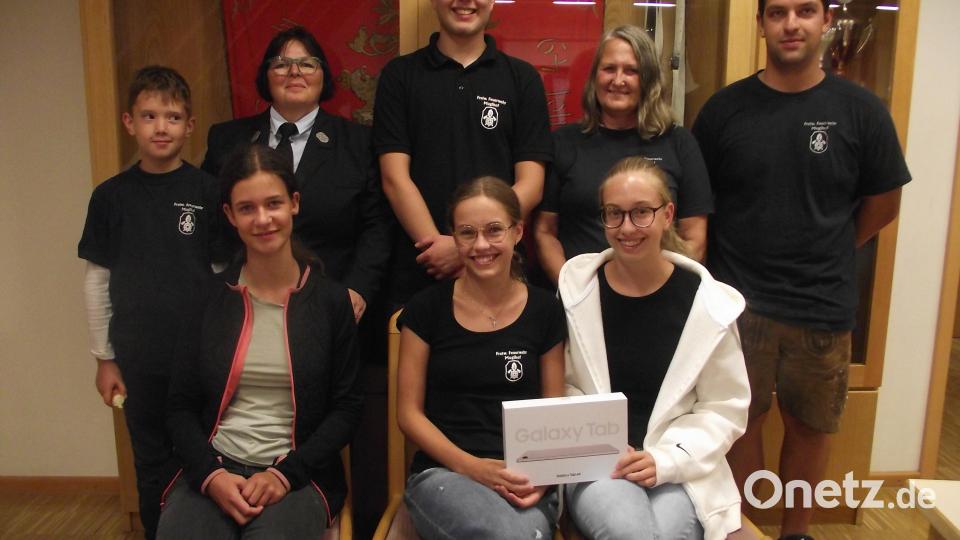 Die Gewinner der Tombola beim Muglhofer Dorffest. (Sitzend, von links) Anna Heimann und die Geschwister Anna und Katharina Winderl. Dahinter stehend David Winderl in der Mitte. Rechts daneben Lydia Götz, links Glücksbringer Arian Voith, daneben die Feuerwehrvorsitzende Sieglinde Fleischmann und rechts Kommandant Markus Balk. Bild: ror