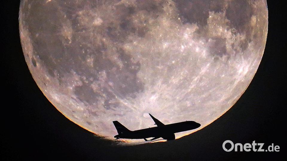Ein Flugzeug passiert den Vollmond über London. Bild: Victoria Jones