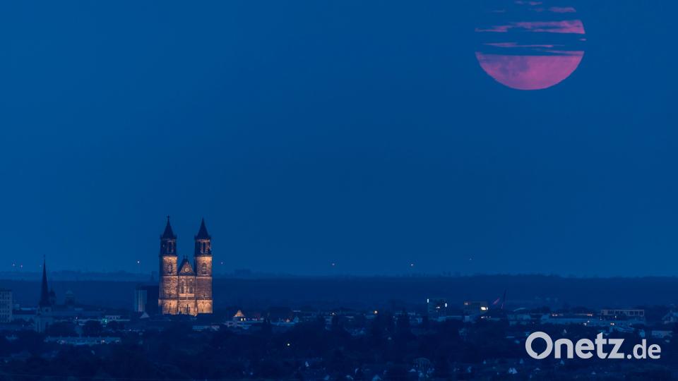 Der Supermond ist hinter einem Wolkenband neben dem Magdeburger Dom zu sehen. I Bild: Stephan Schulz