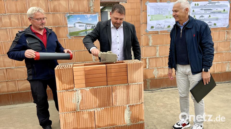 Bürgermeister Markus Ludwig (Mitte) bereitet das Zementbett für die Rolle mit Zeitdokumenten, die Feuerwehrkommandant Gerd Kraus (links) in Händen hält; mit im Bild Architekt Olaf Götzer. Bild: Eichl