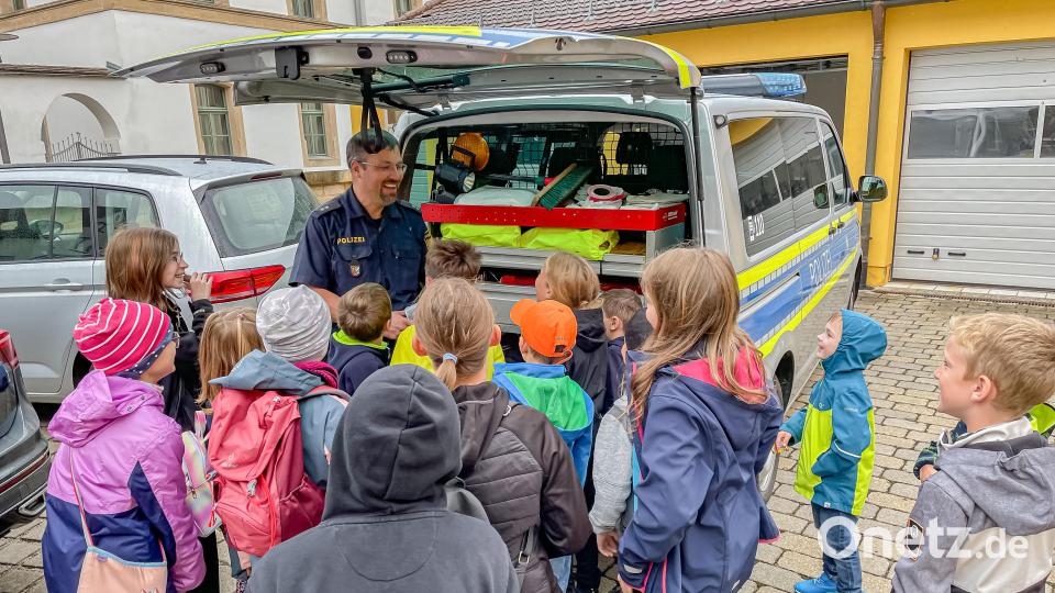 Polizeioberkommissar Carsten Landgraf erklärt den Kindern die Arbeit der Polizei. Bild: Hans Walter/exb