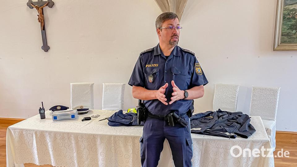 Polizeioberkommissar Carsten Landgraf erklärt den Kindern die wichtigsten Gegenstände bei der Polizeiarbeit. Bild: Hans Walter/exb