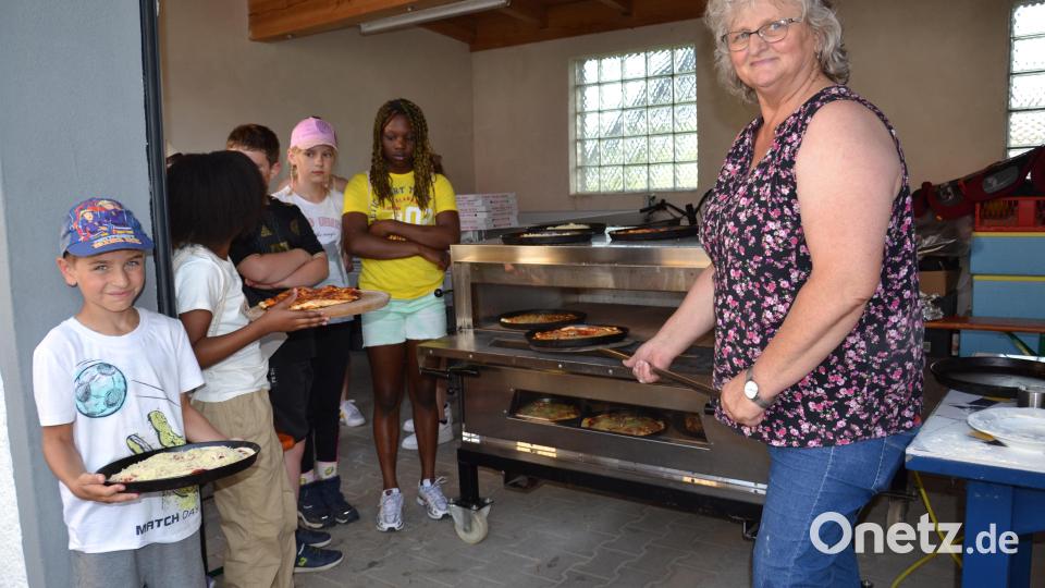 Maria Bayer-Schmidt (rechts)vom Frauenbund Moosbach zeigt den Kindern welche Kräuter essbar sind und auf der Pizza lecker schmecken. Bild: gi
