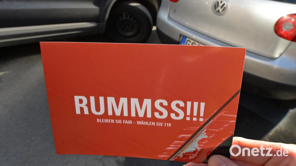 «Rummss!!!» steht auf dieser Postkarte, die vor eine gestellte Unfallsituation gehalten wird. Die Aktion in Niedersachsen erinnerte Fahrer daran, im Falle eines kleinen Unfalls „fair“ zu bleiben und die Polizei zu informieren. Symbolbild: Holger Hollemann/dpa