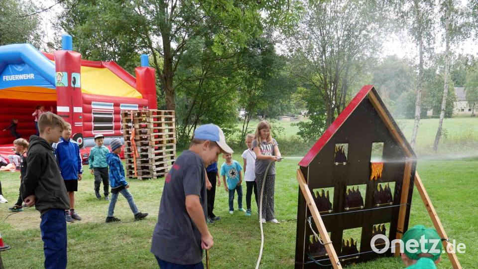 An der Kübelspritze versorgt die Jungfeuerwehr die Kinder mit reichlich Wasser zum Löschen. Bild: gz