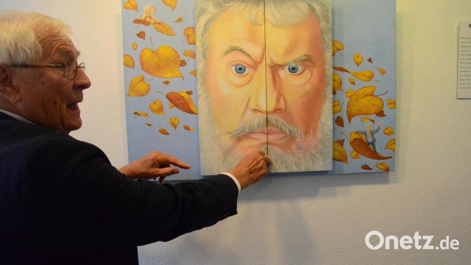 Heimatkreisvorsitzender Wolf-Dieter Hamperl vor einem aufklappbaren Selbstportrait des Künstlers Bernd Fleißner, hinter dem sich eine gemalte Biographie verbirgt. Bild: Kunz