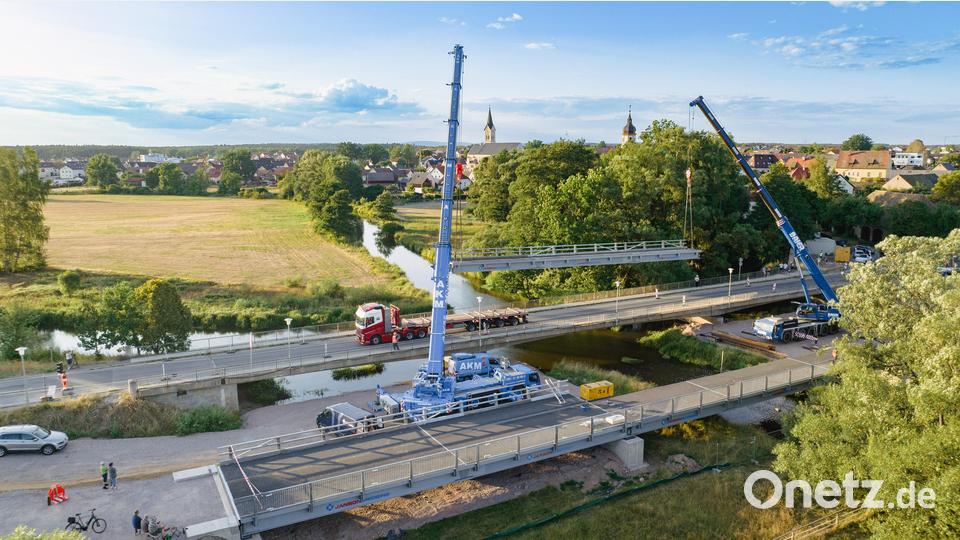 Ein Kran hob im Juli 2022 ein Stahlteil für die Behelfsbrücke (vorne) über die Haidenaab bei Mantel ein. Die zweite Brücke dahinter ist die eigentliche alte Haidenaabbrücke. Sie wurde im August 2022 abgerissen. Archivbild: Drohnenbilder-Weiden, Peter Wurm/exb