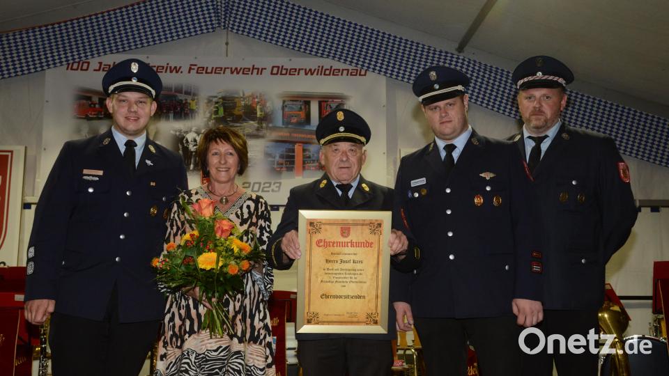 Die Führungsspitze der Feuerwehr Oberwildenau überreicht Josef Kres die Ehrenurkunde zur Ernennung zum Ehrenvorsitzenden. Ehefrau Maria darf sich über einen bunten Blumenstrauß freuen. Bild: bey