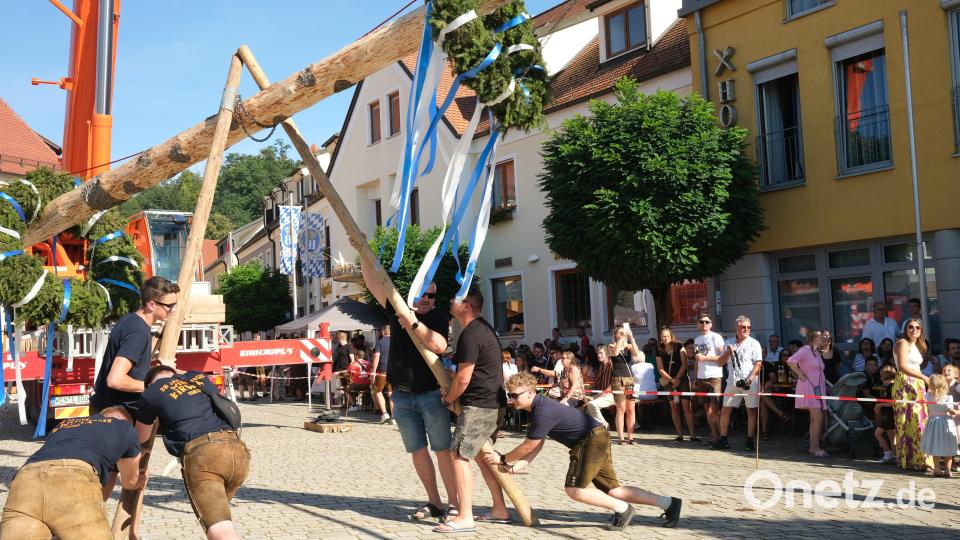 Mit Muskelkraft stellten die Kirwaburschen den Kirwabaum auf, beobachtet von zahlreichen Zuschauern, die am Samstag zum Wernberger Marktplatz gekommen waren. Bild: Hirsch