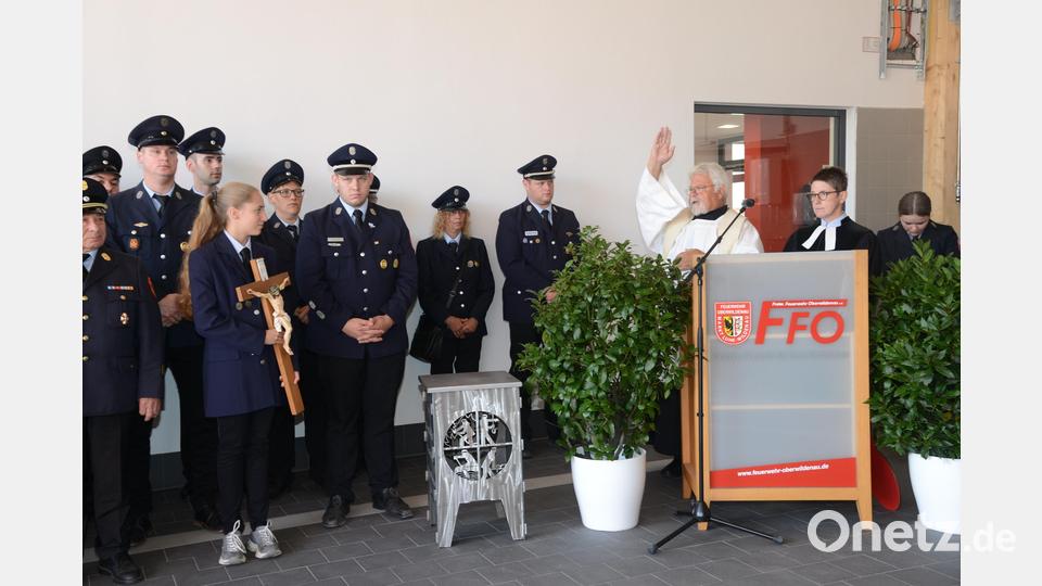 Pfarrer Arnold Pirner und Pfarrerin Heidi Landgraf segnen das von Josef und Maria Kres gestiftete Kreuz mit der Christusfigur, das im Feuerwehrgerätehaus einen würdigen Platz haben wird. Bild: bey