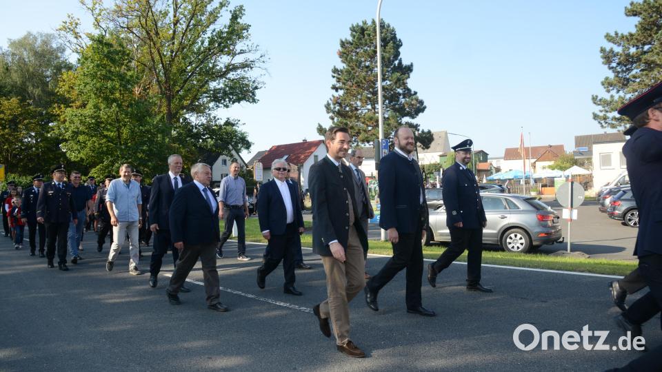 MdL Stephan Oetzinger, Landrat Andreas Meier und Bürgermeister Sebastian Hartl führen den Zug der Gäste von der St. Michaelskirche zum neuen Feuerwehrgerätehaus an. Bild: bey