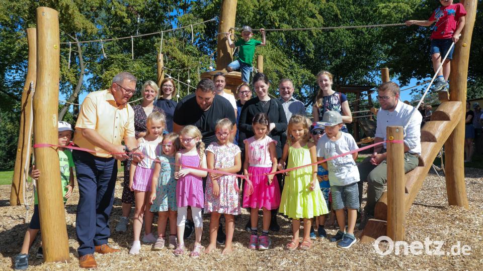 Bürgermeister Martin Preuß schneidet das Band im Beisein der Kindern durch. Bild: Wolfgang Steinbacher