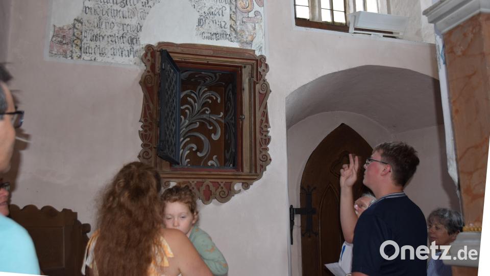 Florian Rieger zeigt die bemalte Wandnische im Altarraum der Eschenfeldener Kirche, die bei der bisher letzten Renovierung zum Vorschein gekommen ist. Bild: wku