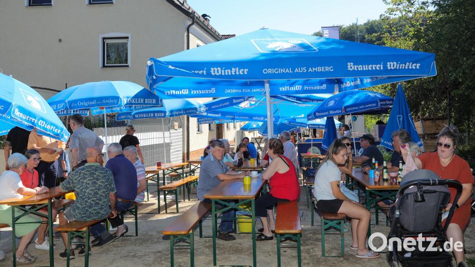 Die Familien sitzen zusammen unter Sonnenschirmen bei dem Stadtteilfest. Bild: Wolfgang Steinbacher