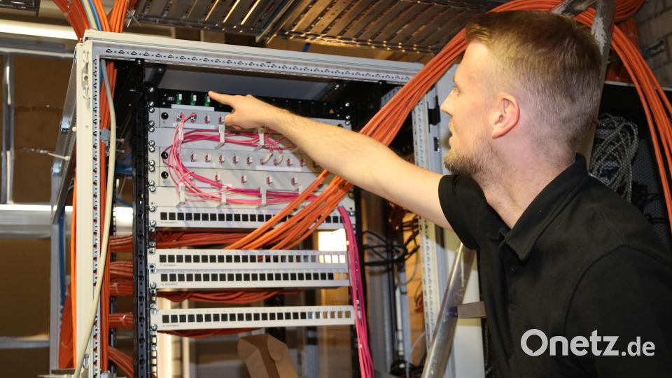 Systemadministrator Patrick Schieder zeigt im Technikraum des Kepler-Gymnasiums, wo das Inhouse-Glasfaserkabel endet. Bild: Pressestelle Stadt Weiden/exb