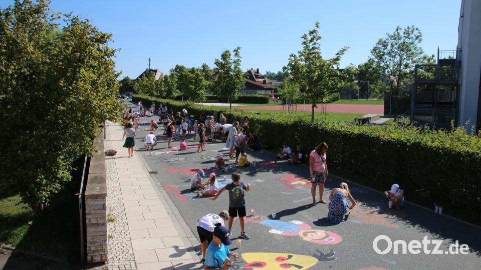 Über 60 Kinder bemalten den Alten Weg vor der Schule. Dies soll die Autofahrer an den Schulbeginn erinnern. Bild: sne