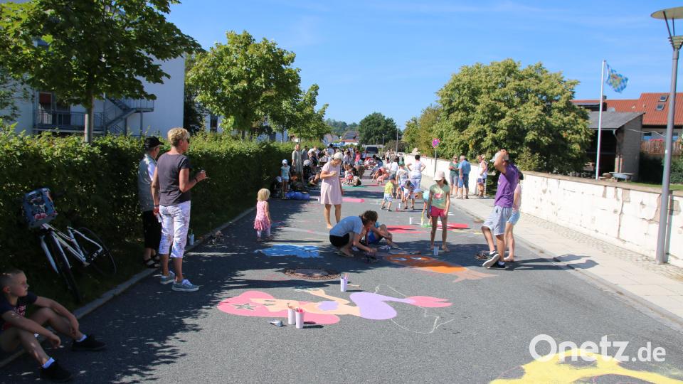 Über 60 Kinder bemalten den Alten Weg vor der Schule. Dies soll die Autofahrer an den Schulbeginn erinnern. Bild: sne