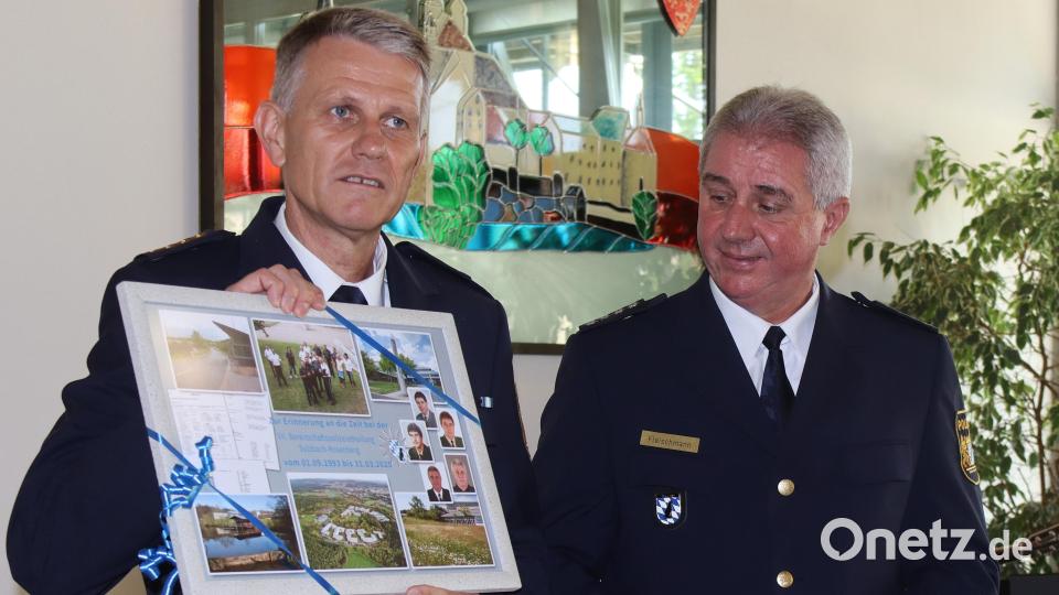 Der Leitende Polizeidirektor Matthias Messer (links) überreicht Josef Fleischmann eine Collage mit Bildern aus seiner Zeit bei der Bereitschaftspolizei. Bild: mfh
