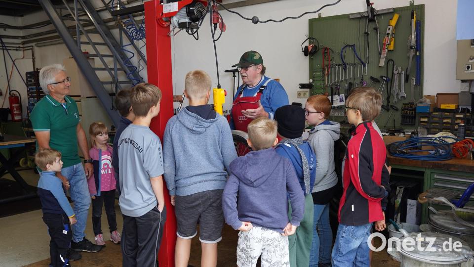 Ewald Oppl (in roter Latzhose) erklärte den Kindern einfache Reparaturen am Fahrrad. Bild: Dominik Göhl/exb