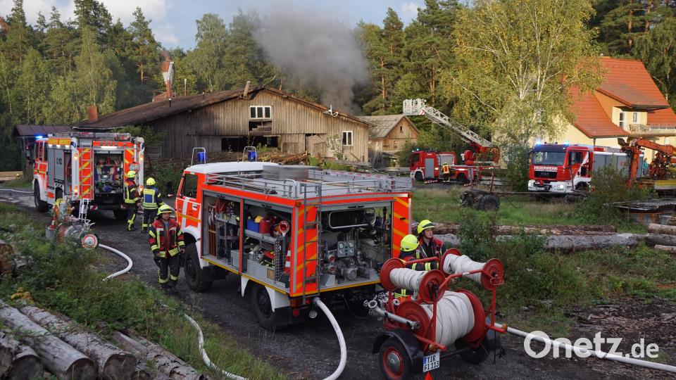 Rauchkerzen markierten das Brandobjekt auf dem Sägewerk. Die Immenreuther Brandschützer auf der linken und Kemnath auf der rechten Seite, deren Aufgabe es war, mittels Drehleiter das Wohngebäude und den Wald vom Übergriff des Feuers zu bewahren. Bild: bkr