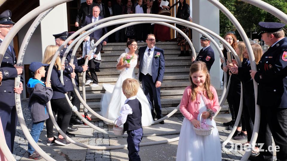 Markus Uschold und seine Maria (geborene Ertl) geben sich in der katholischen Nikolauskirche das Ja-Wort. Nach der Trauung durchschreiten sie ein Schlauchspalier. Bild: wlr