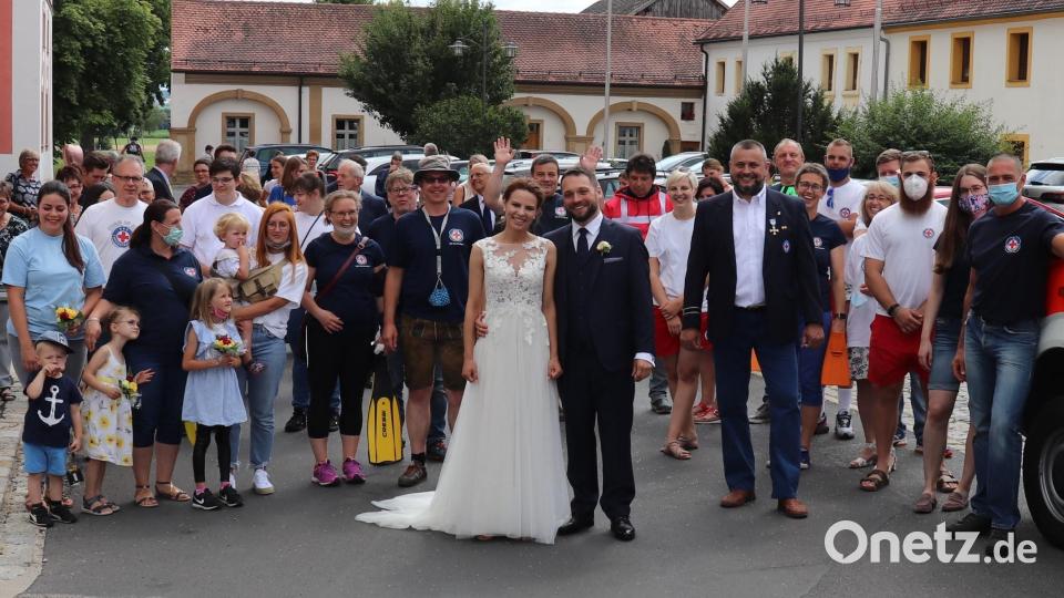 Das Brautpaar stellt sich mit seinen den Wasserwachtmitgliedern zum Foto auf. Bild: myd