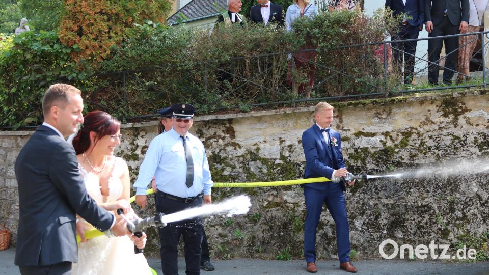 Die Feuerwehr Eschenfelden hatte mit dem Eimerumspritzen direkt die erste Aufgabe für das jung vermählte Paar. Bild: lei