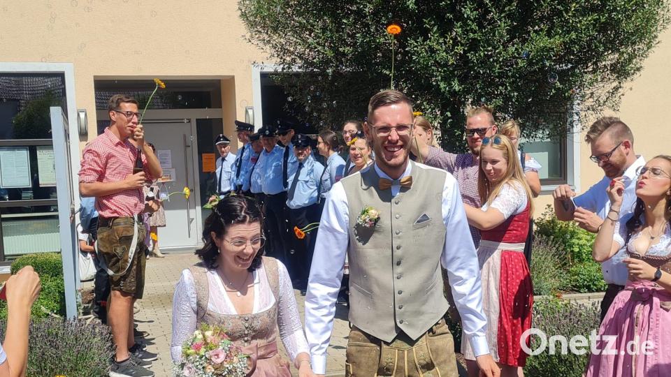 Nach dem Jawort verlassen Michael Lösch und seine Stephanie das Neukirchener Rathaus durch das Spalier aus Feuerwehrleuten, Kirwapaaren und Bergwachtlern.. Bild: lei