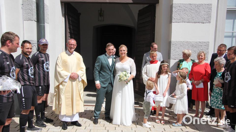 Judith und Christian Beer beim Verlassen der Klosterkirche mit Stadtpfarrer Dr. Thomas Vogl (links) sowie den Brautkindern Leni, Theo, Benno und Anna und den Fußballern des SC Mähring. Bild: kro