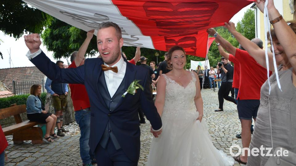 Es dürfte wohl der schwierigste Gang für den bekennenden 1860er Fan gewesen sein, durch die FC-Bayern-Fahne zu marschieren. Doch mit der Braut an der Hand meisterte der Bräutigam diese Aufgabe souverän. Bild: dob