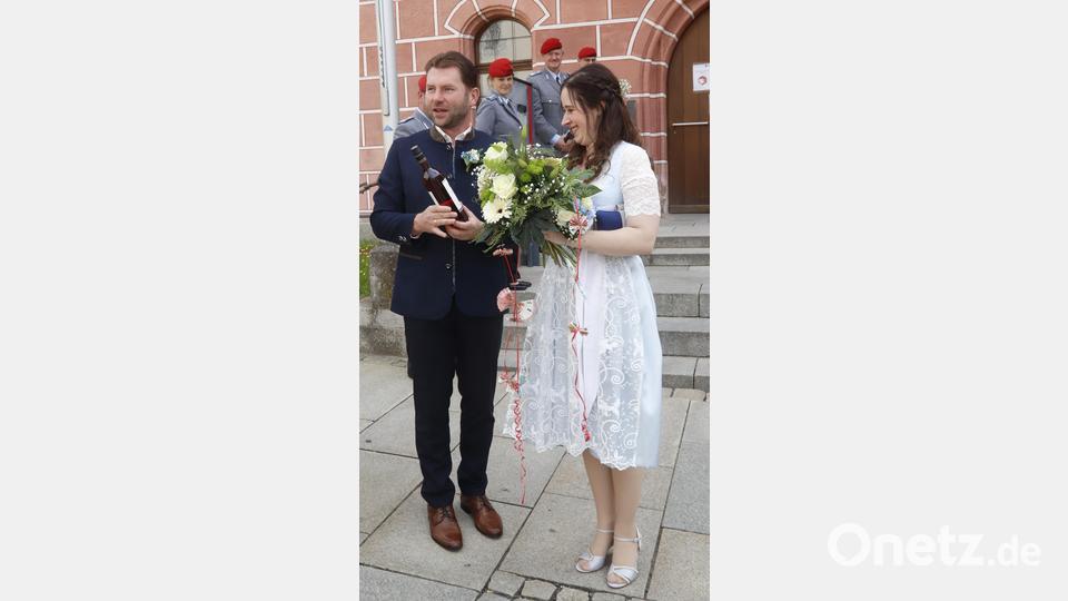 Das Brautpaar bedankt sich mit einem guten Tropfen für die Glückwünsche. Bild: mfh