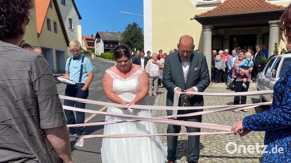 Bänder mussten Marina und Jürgen Schwägerl nach dem Verlassen der Kirche durchschneiden. Bild: kro