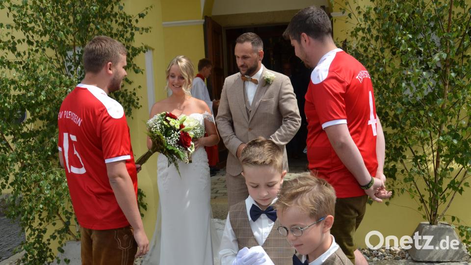 Melanie Prößl aus Woppenrieth bei Waldthurn und Patrick Götz aus Vohenstrauß geben sich in der Pfarrkirche "Mariä Himmelfahrt" in Böhmischbruck das Jawort. Nach dem Verlassen der Kirche gratulieren die Sportler des TSV Pleystein. Bild: dob