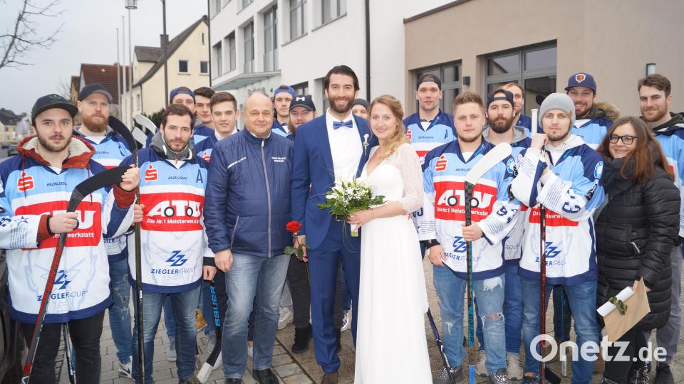 Christian Wolf und seine Frau Mareike schreiten nach ihrer standeamtlichen Hochzeit vor Bürgermeister Ernst Lenk im Schirmitzer Bürgersaal durch ein langes Gratulationsspalier von Freunden und Bekannten sowie den Eishockey-Spielern des EV Weiden. Bild: du