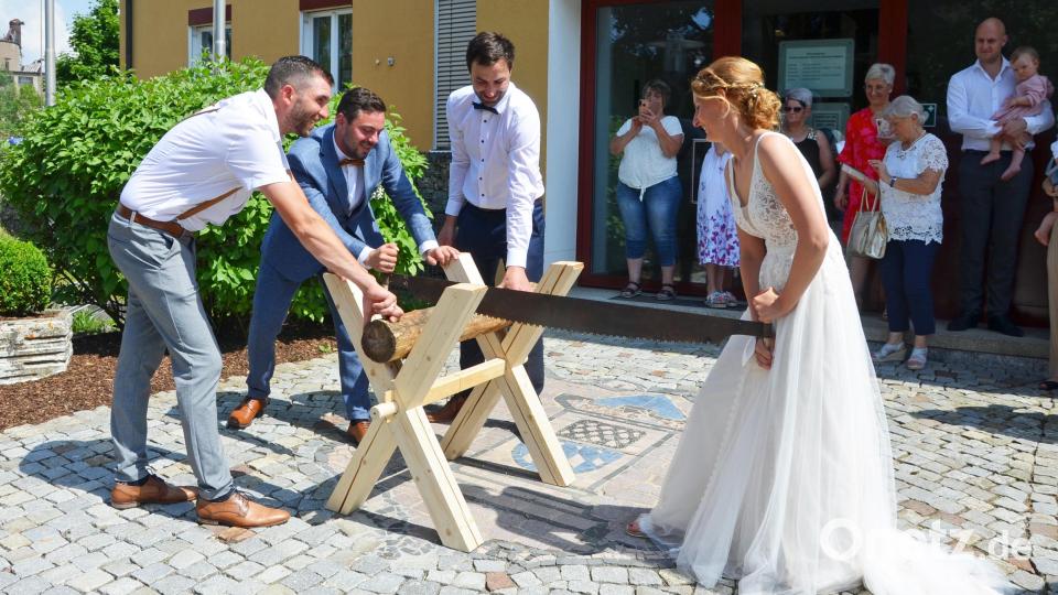 Christopher (Zweiter von links) und Isabell Leipold sägen gemeinsam einen Baumstamm. Bild: ü