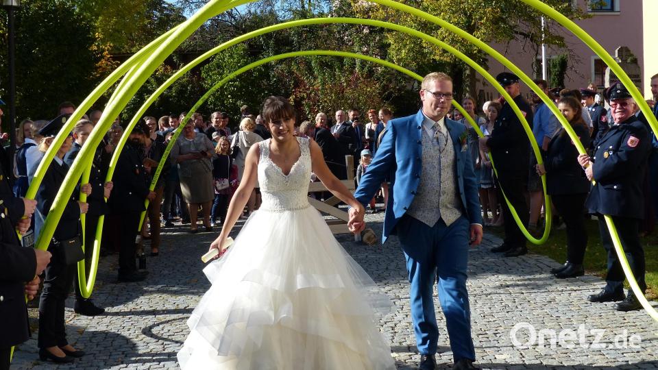 Das Paar durchschreitet den Schlauchbogen der Feuerwehr. Bild: hme