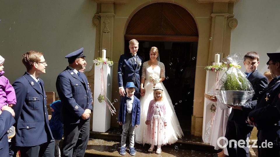Die Brautleute am Kirchenportal mit Spalier der Feuerwehr Heinersreuth. Bild: hzi
